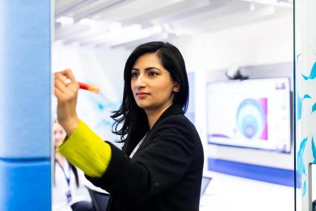 Professional woman writing on a whiteboard in an office